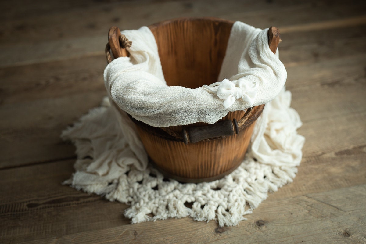 Carved wooden newborn bucket prop for a lighting-focused newborn photography setup